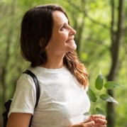 Smiling hiker holding a plant